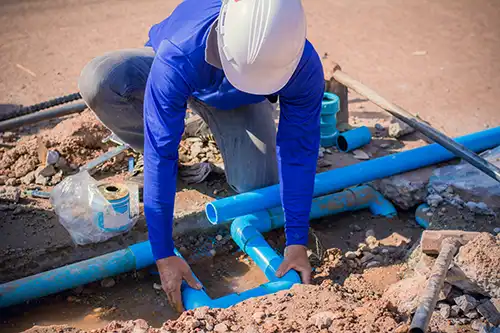 man installing water line pipe